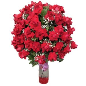 100 red roses in a vase with green plants