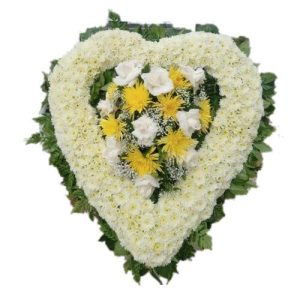 Sympathy white heart arrangement with white and yellow flowers in the center