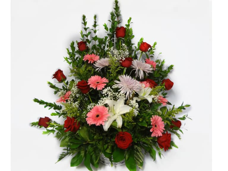Bouquet in a basket with 12 Roses, 7 Gerberas Daisies, 3 Spiders, 2 while Lilies.